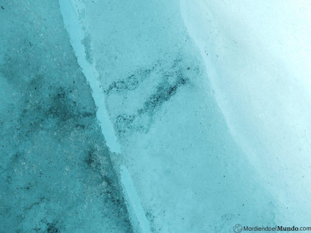 Detalle de grieta en el hielo y marcas negras de ceniza volcanica
